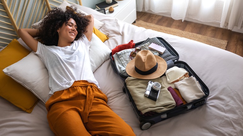 Woman lying next to suitcase