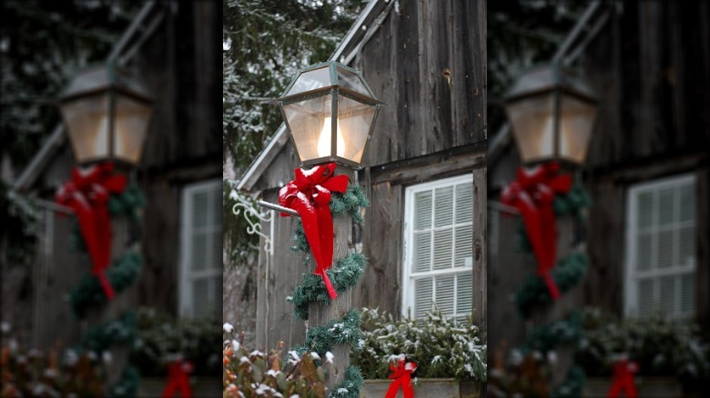 lamppost decorated with garlands and red bow 