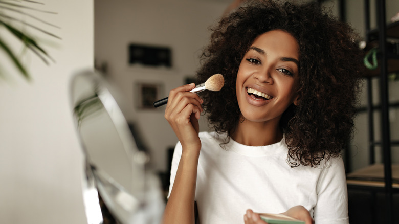 woman applying contour to cheek