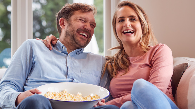 Couple laughing with popcorn
