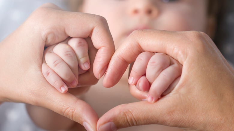 heart-hand gesture with baby