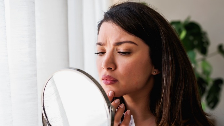 Woman checking for acne