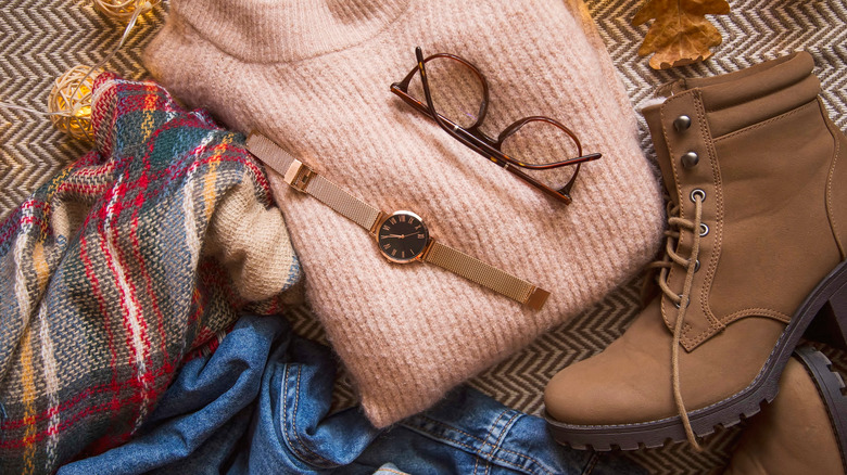 Flat lay of fall outfit surrounded by leaves and lights