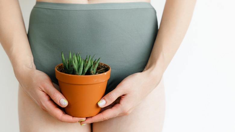 woman with plant over bikini