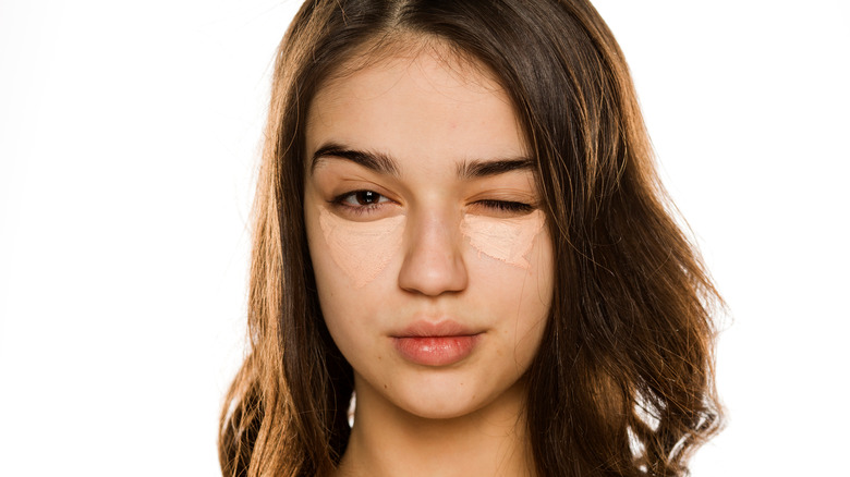 Woman winking with eye concealer 