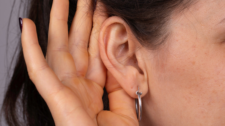 Woman cupping her ear 