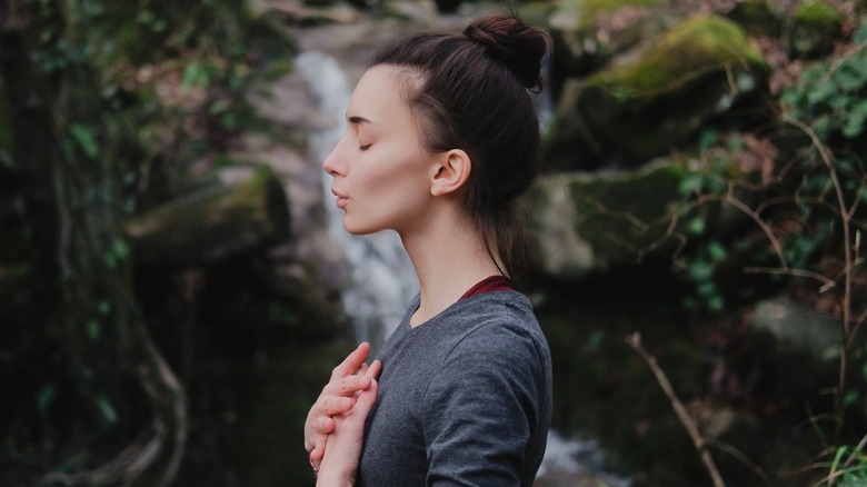 woman outside with her eyes closed