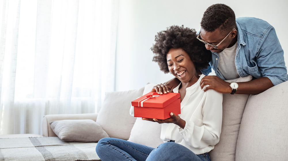 Couple laughing, opening gift