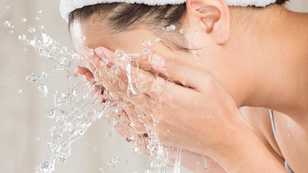 Woman splashing water on face