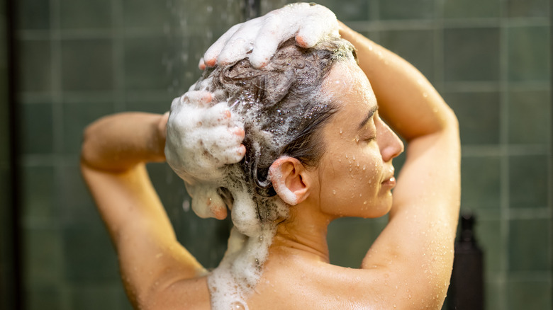 Young woman shampooing her hair 