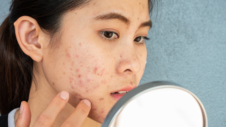 A woman inspecting her face