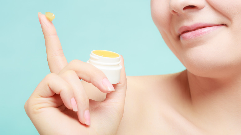 Woman holding a small vaseline jar 