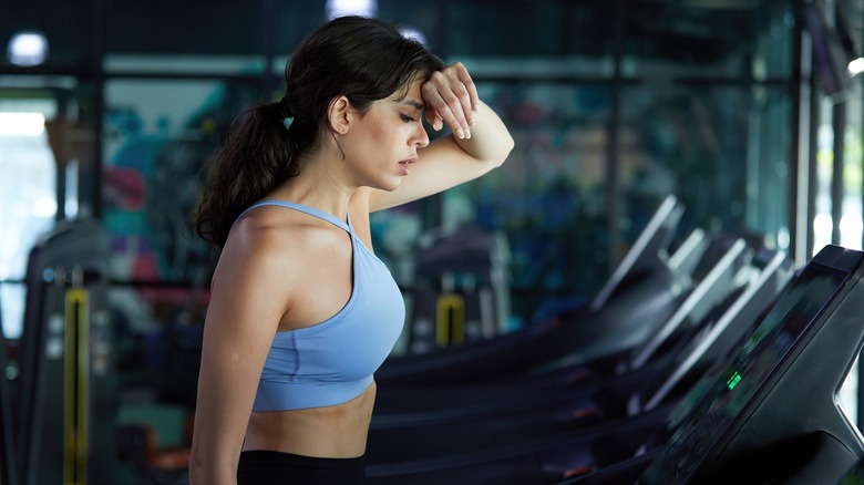 A woman sweating on the treadmill