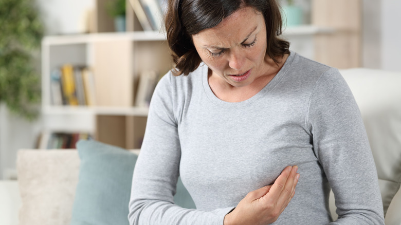 woman holding her breast in pain