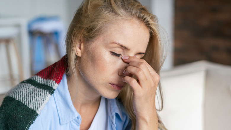 sick woman pinching nose