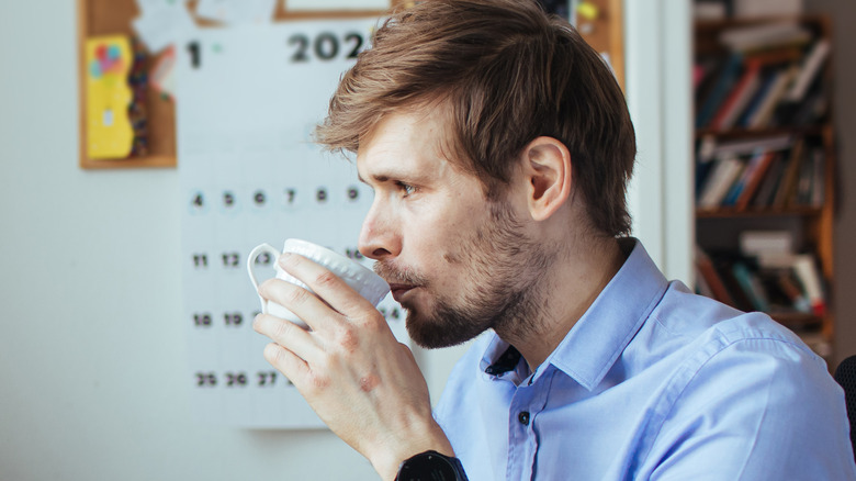 man drinking coffee at desk