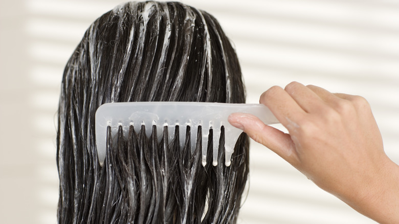 Woman putting conditioner in hair