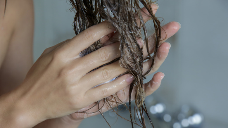 Woman applying conditioner to hair