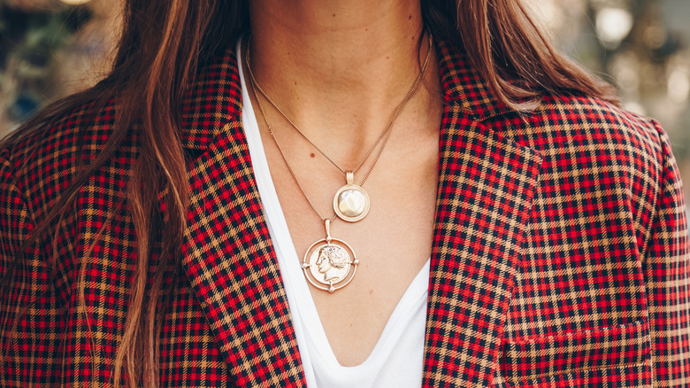 Woman wearing layered necklaces with a blazer