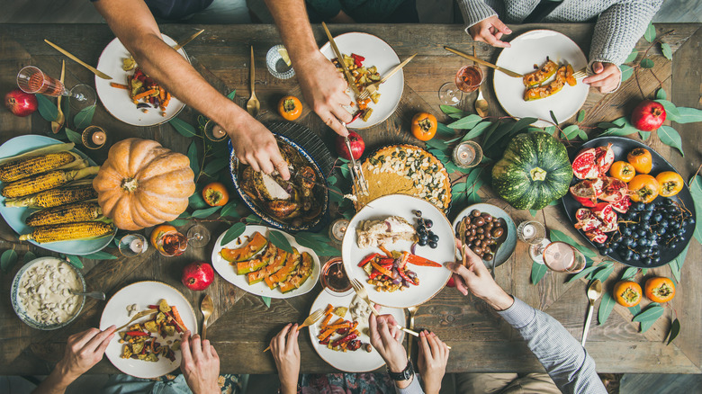 hands digging into Thanksgiving feast