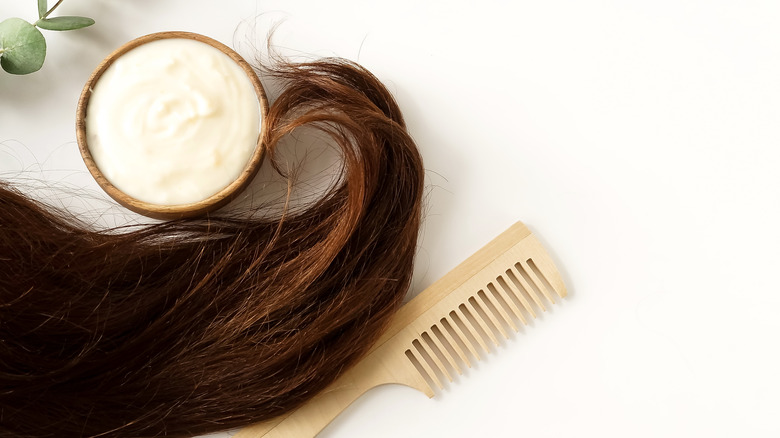 Hair sitting next to product and a comb