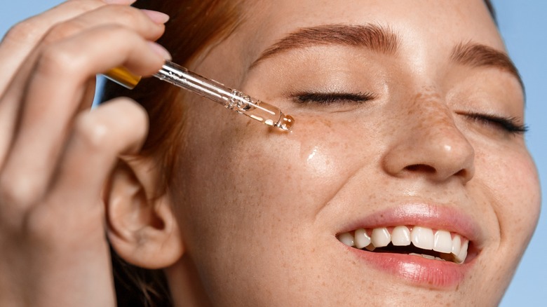 A woman applying serum