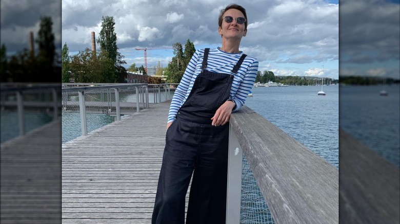 a woman in a striped shirt and overalls