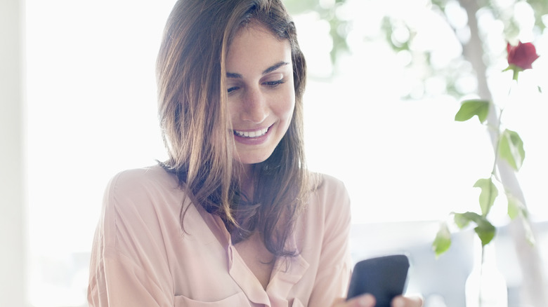 smiling woman texting on phone