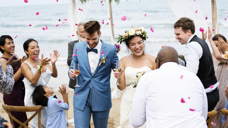 Bride and groom with guests at beach wedding