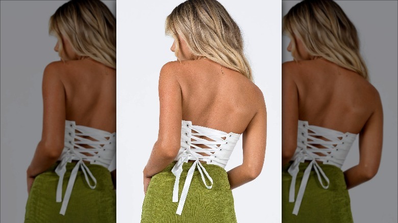 back of blond woman wearing laced corset