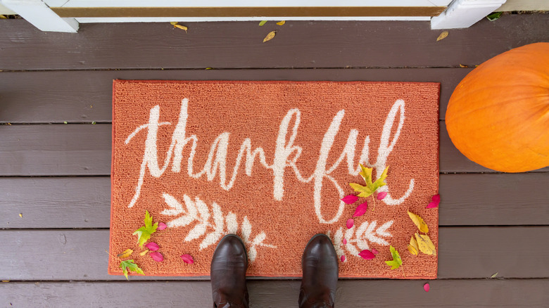 "Thankful" porch mat with boots and fall leaves