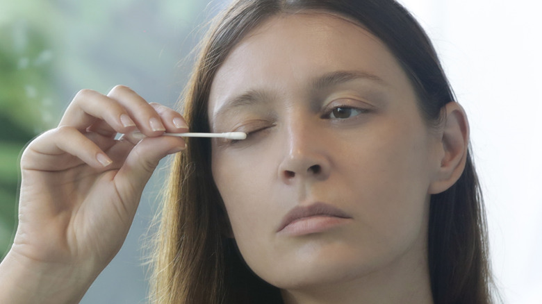 Woman applying eyelash serum