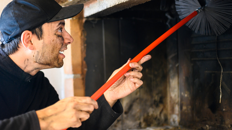 man cleaning fireplace