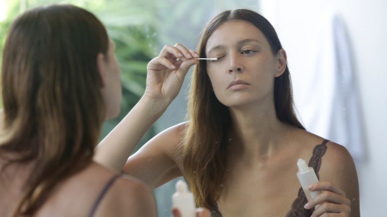 Woman applying an eyelash serum