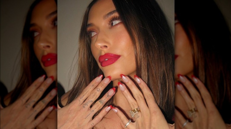 Hailey Bieber posing with red nail design