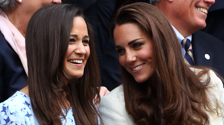 Kate and Pippa Middleton smile and clap