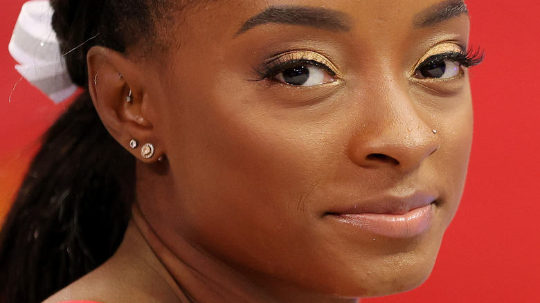 Simone Biles smiling with gold eye makeup