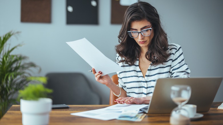 Woman looking at bills with a laptop