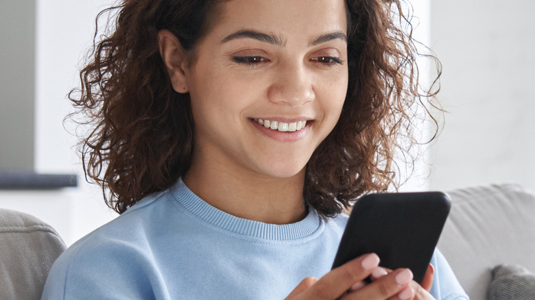 Woman smiling into her phone