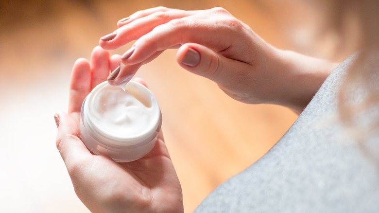 Woman with lotion on fingers