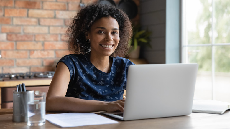 Smiling woman working on laptop