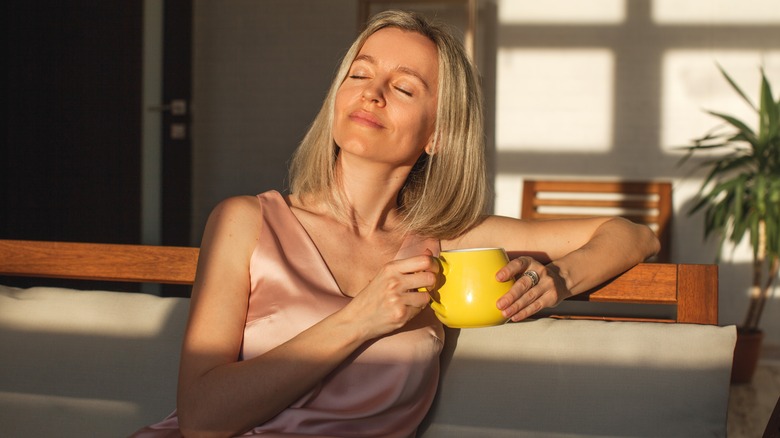 woman relaxing while holding mug