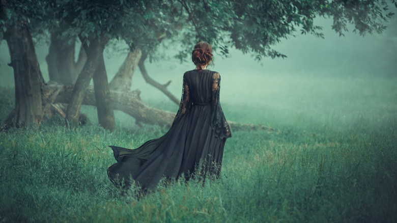 Woman in a black lace gown in a forest