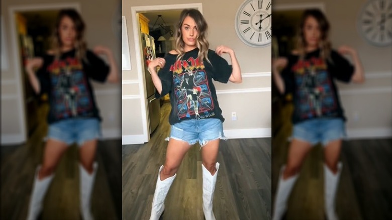 Woman wearing AC/DC T-shirt, denim shorts, and white boots