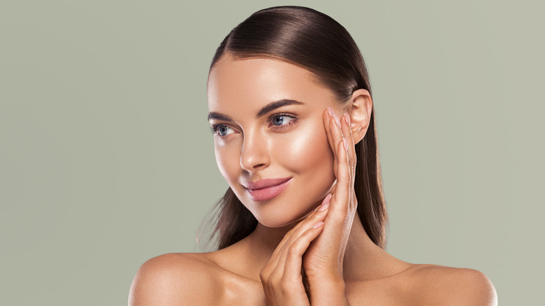 Woman smiling and touching her cheek