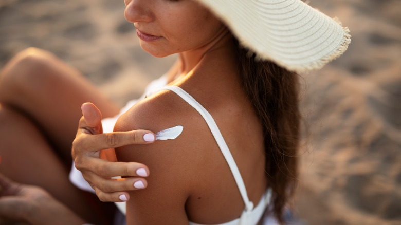 Woman applying sunscreen while at the beach