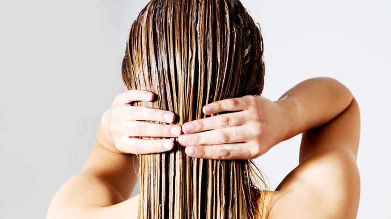 Woman applying conditioner to her hair 