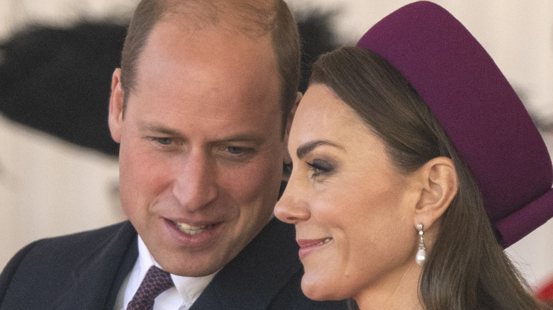 Prince William speaking to smiling Kate Middleton
