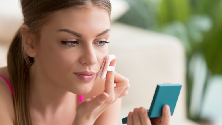 woman using powder puff makeup