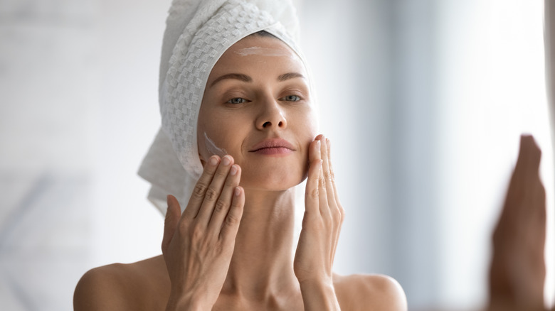 Woman moisturizing her face